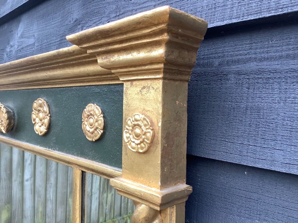 A 19th-century giltwood triple plate overmantel mirror featuring spiral-twist side columns, a dark painted frieze with gold rosettes, and a central carved shell motif. View IV
