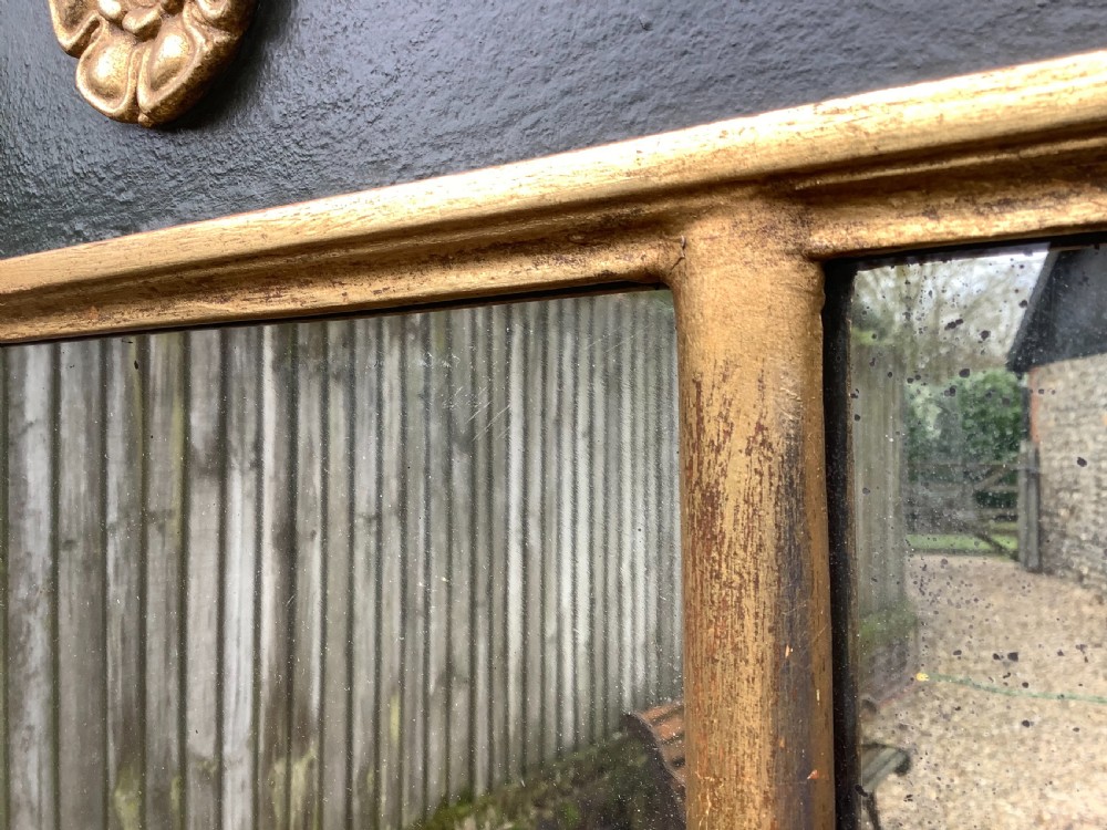 A 19th-century giltwood triple plate overmantel mirror featuring spiral-twist side columns, a dark painted frieze with gold rosettes, and a central carved shell motif. View XI