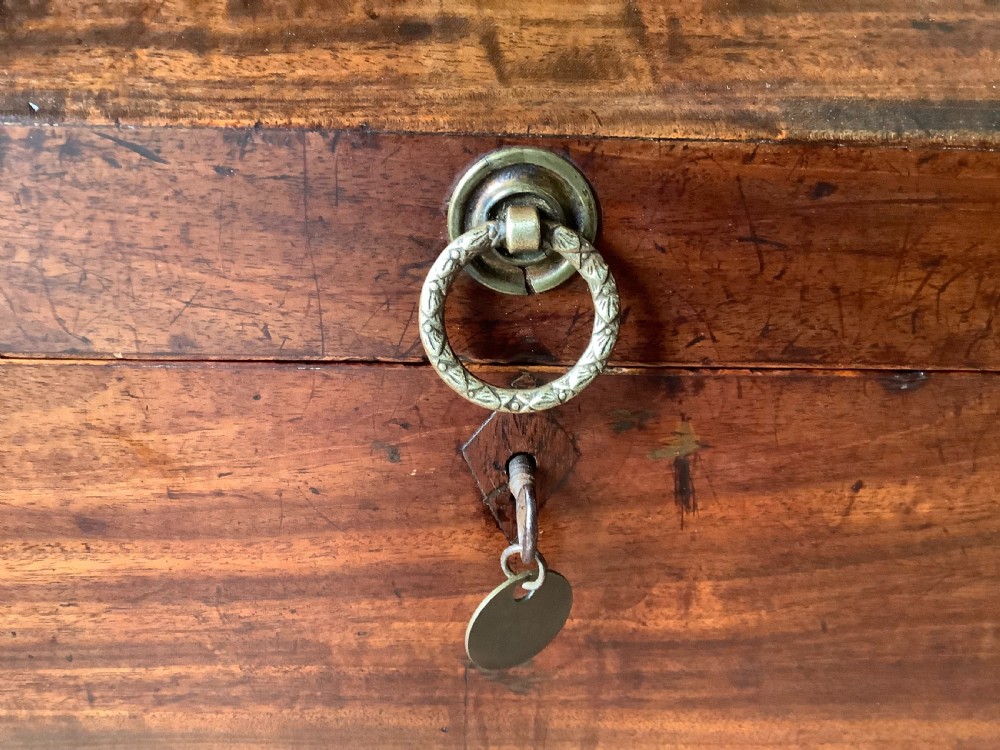 A Georgian mahogany cellarette featuring a domed lid, turned legs, flame mahogany wood grain, and side brass handles. View VII