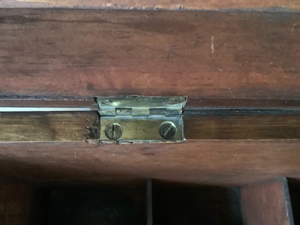 A Georgian mahogany cellarette featuring a domed lid, turned legs, flame mahogany wood grain, and side brass handles. View X
