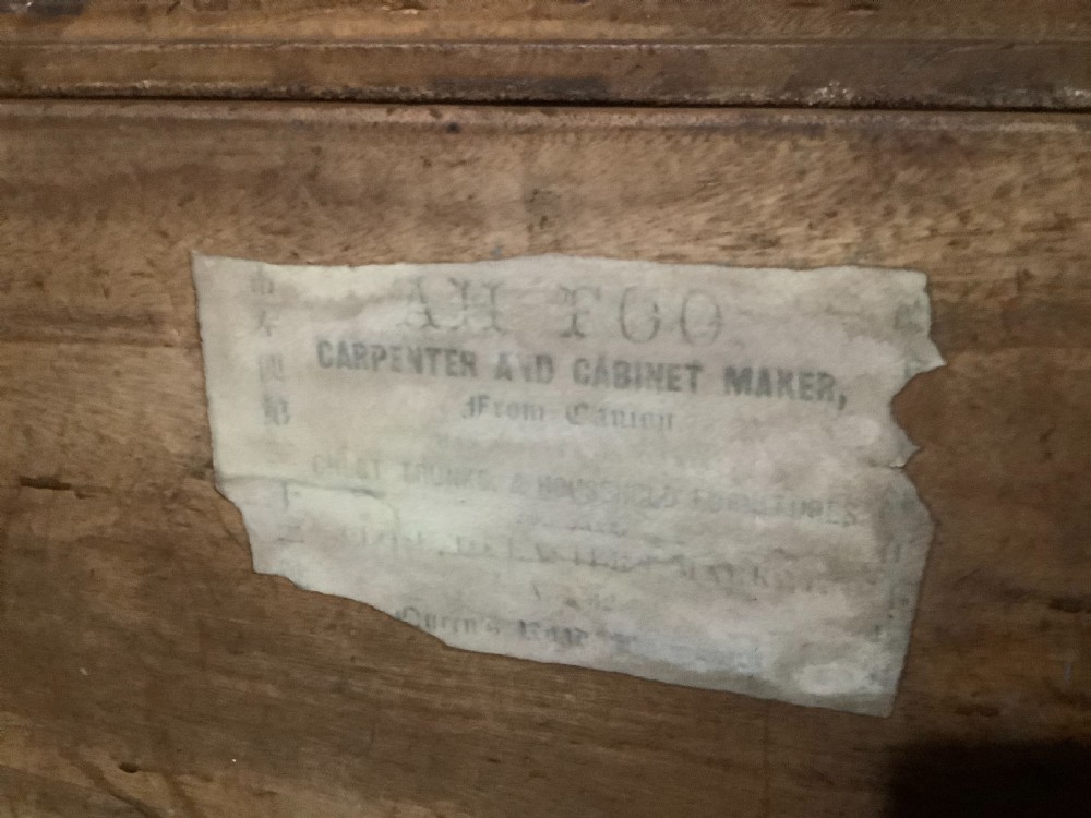 A rectangular camphor wood campaign trunk featuring flush brass corner brackets, central brass escutcheon, side carrying handles, and visible dovetail joinery. View XII