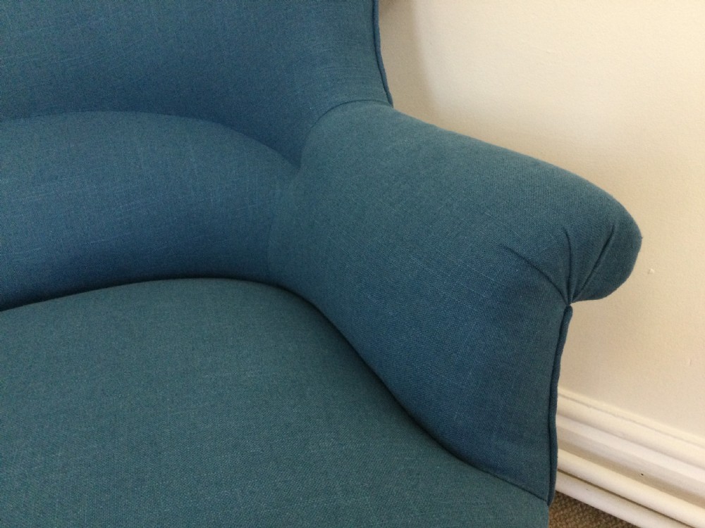 A 19th-century French crapaud armchair upholstered in teal blue fabric with dark wooden legs. View II