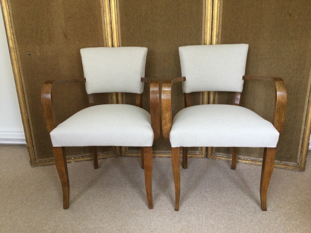 A pair of French Art Deco bridge chairs featuring curved wooden arms and light beige fabric upholstery. View II