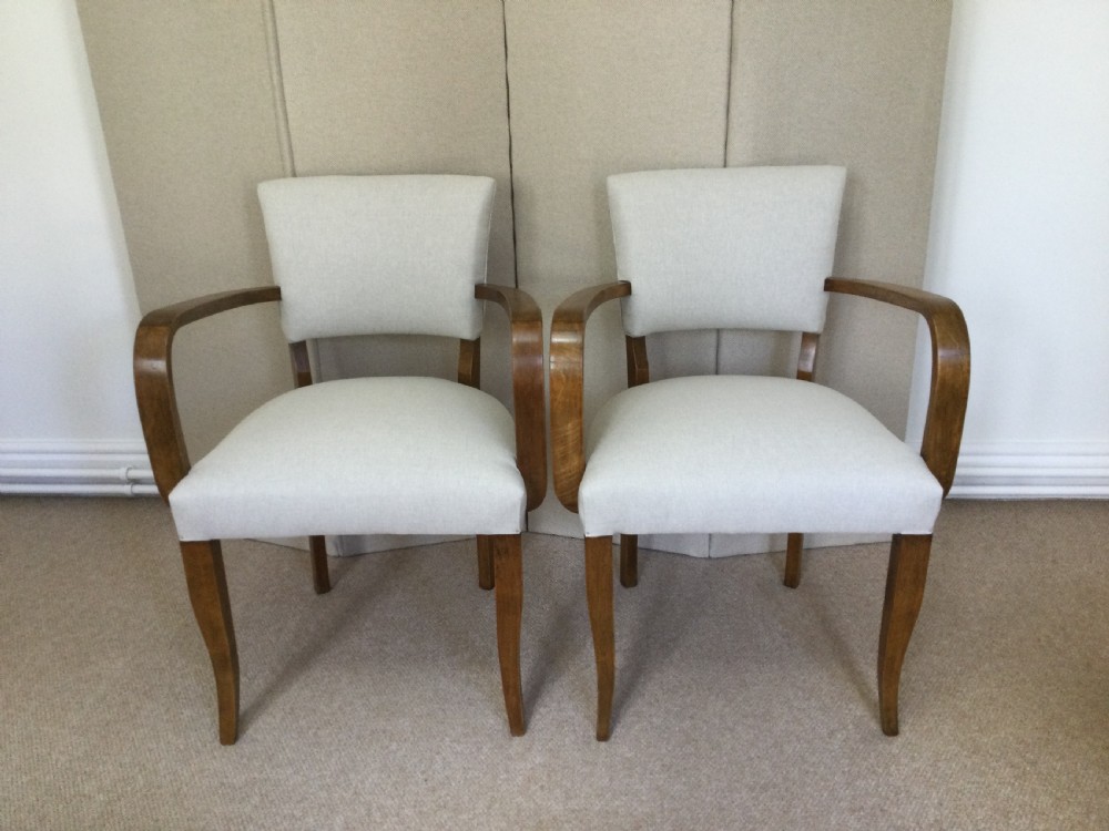 A pair of French Art Deco bridge chairs featuring curved wooden arms and light beige fabric upholstery. View III