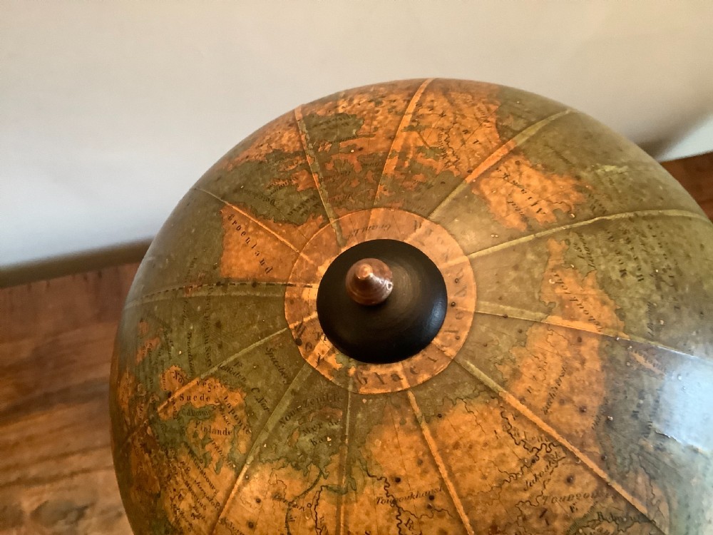 A small 19th-century French terrestrial globe with green oceans, mounted on a turned ebonised wood stand with brass fittings. View X