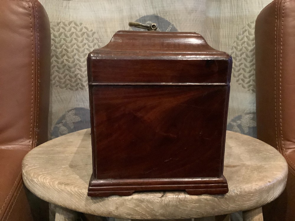 A rectangular Georgian mahogany tea caddy featuring a hinged lid, a brass top carrying handle, and an ornate brass keyhole escutcheon. View VI
