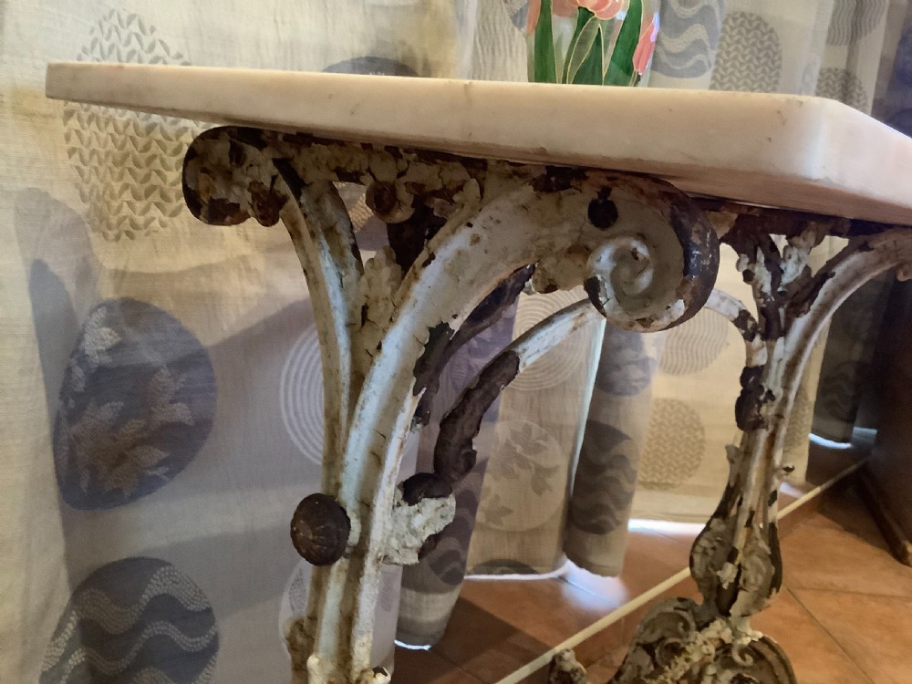 A nineteenth-century console table featuring a rectangular white marble top supported by a distressed white-painted cast iron base with ornate scrollwork. View VI