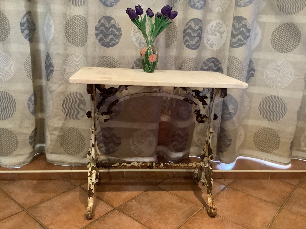 A nineteenth-century console table featuring a rectangular white marble top supported by a distressed white-painted cast iron base with ornate scrollwork. View VIII
