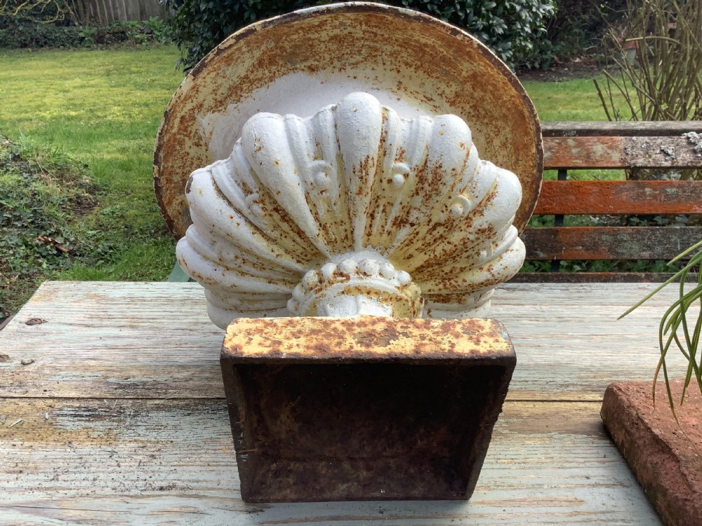 A pair of weathered off-white cast iron table urns featuring classical gadrooned decoration and square pedestal bases. View VII