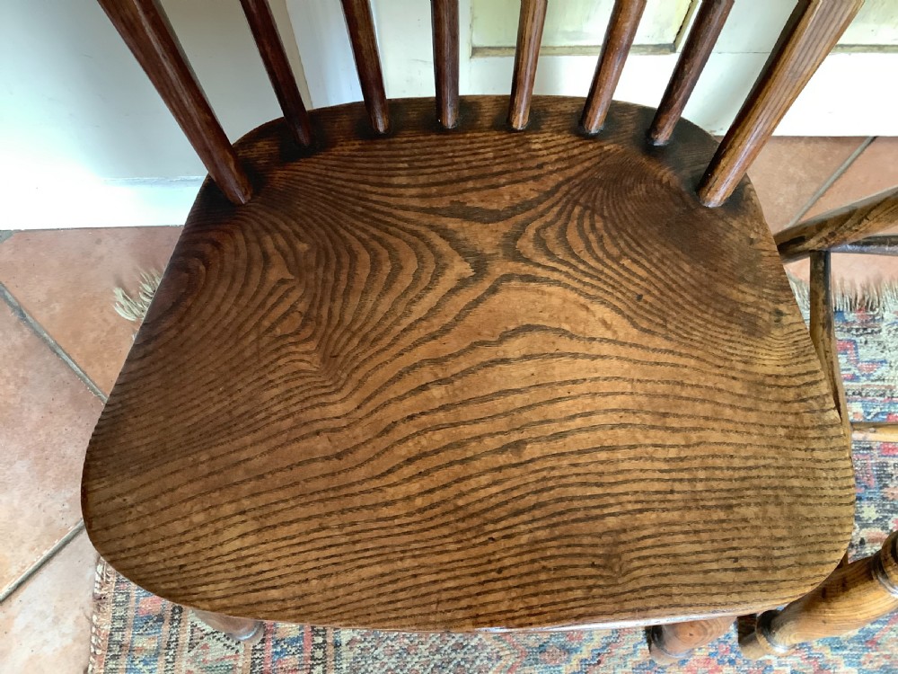 A near pair of antique wooden stick back Windsor kitchen chairs with hoop backs and turned legs. View V