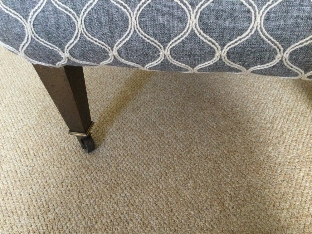 A 19th-century English low-seated slipper chair upholstered in grey patterned fabric with square tapered wooden legs on brass castors. View VI