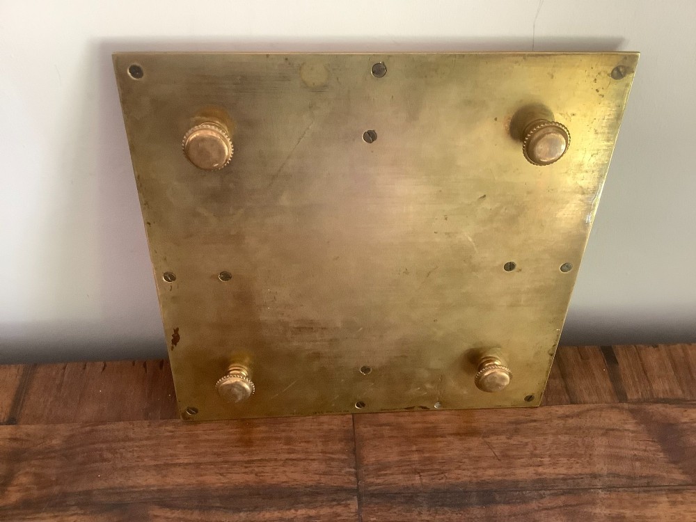 A square Victorian brass inkstand featuring a central domed hinged inkwell resting on a stepped base surrounded by pen channels. View VI