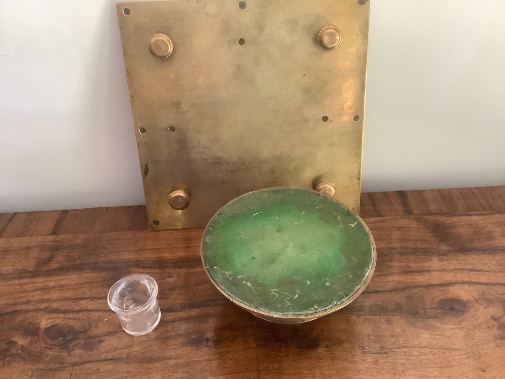 A square Victorian brass inkstand featuring a central domed hinged inkwell resting on a stepped base surrounded by pen channels. View VII