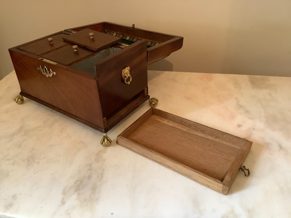 A Georgian mahogany tea caddy featuring brass ball-and-claw feet, a central brass escutcheon, and a top carrying handle. View V