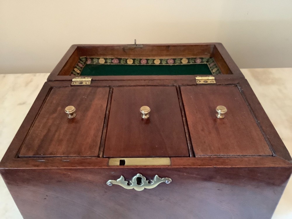 A Georgian mahogany tea caddy featuring brass ball-and-claw feet, a central brass escutcheon, and a top carrying handle. View VII