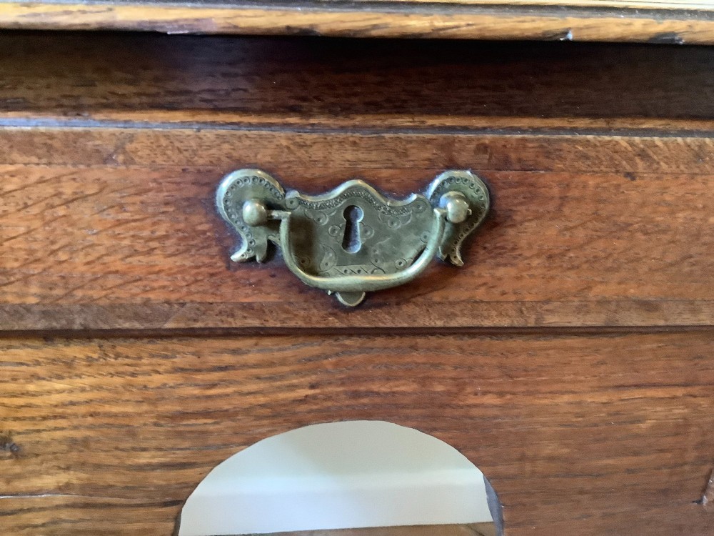 An 18th-century oak lowboy featuring a three-drawer configuration above an arched apron and cabriole legs ending in pad feet. View IV