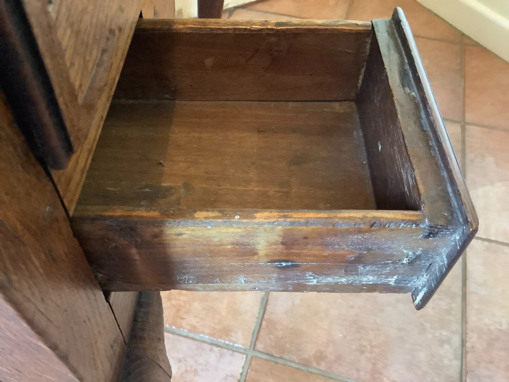An 18th-century oak lowboy featuring a three-drawer configuration above an arched apron and cabriole legs ending in pad feet. View VII