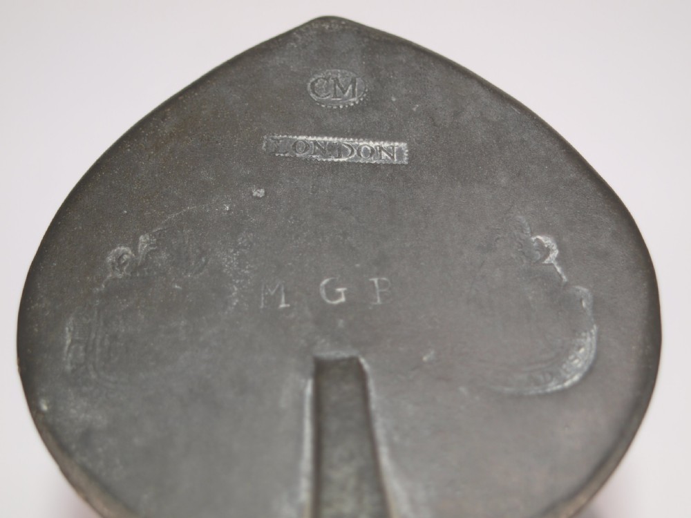 An antique dark grey pewter lidded flagon featuring a bulbous body, flared collar, hinged lid, and handle. View VIII