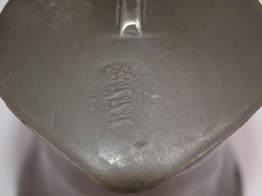 An antique slate grey pewter lidded quart measure featuring a baluster shape, attached strap handle, and hinged lid. View VII