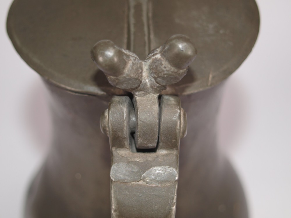An antique slate grey pewter lidded quart measure featuring a baluster shape, attached strap handle, and hinged lid. View VIII
