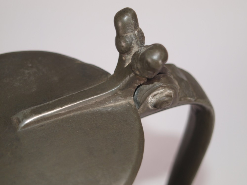 An antique slate grey pewter lidded quart measure featuring a baluster shape, attached strap handle, and hinged lid. View IX