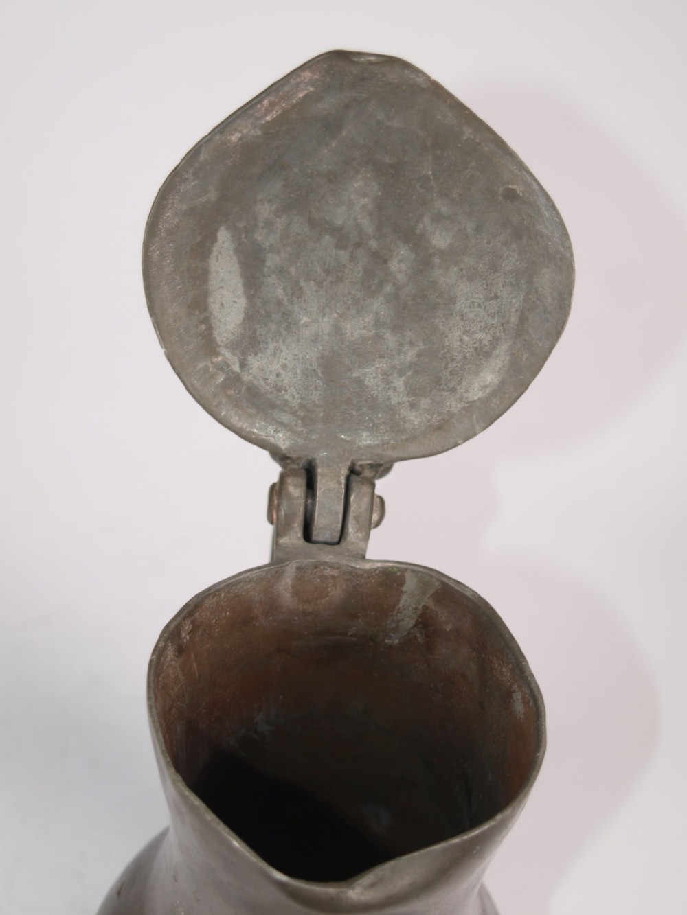 An antique slate grey pewter lidded quart measure featuring a baluster shape, attached strap handle, and hinged lid. View XII