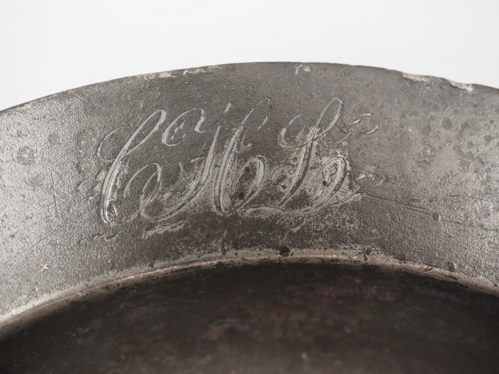 A circular grey antique pewter deep plate featuring a wide plain rim engraved with monogrammed initials at the top and the date 1845 at the bottom. View III