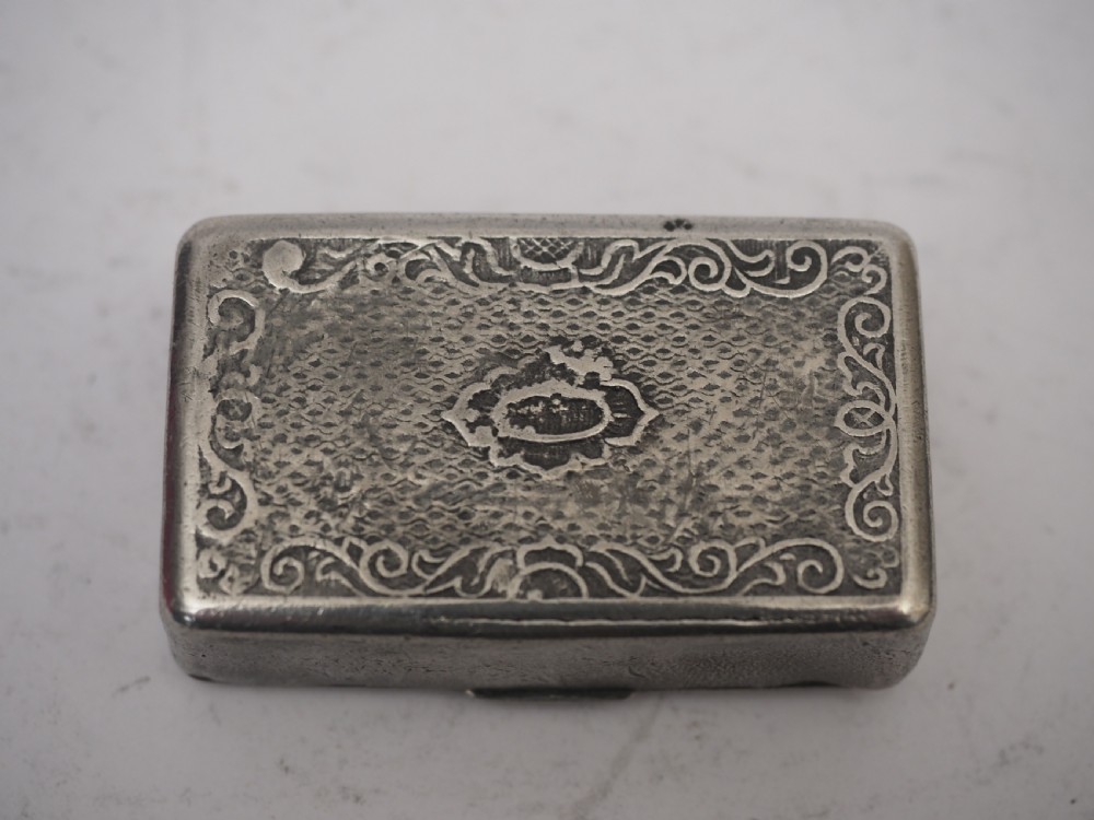 A rectangular antique pewter snuff box featuring an engraved central cartouche surrounded by scrollwork and textured engine-turned patterning. View IV