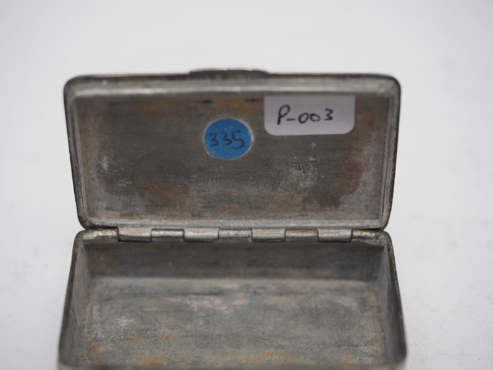 A rectangular antique pewter snuff box featuring an engraved central cartouche surrounded by scrollwork and textured engine-turned patterning. View VI
