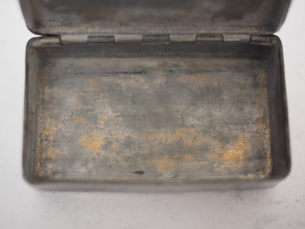 A rectangular antique pewter snuff box featuring an engraved central cartouche surrounded by scrollwork and textured engine-turned patterning. View VII