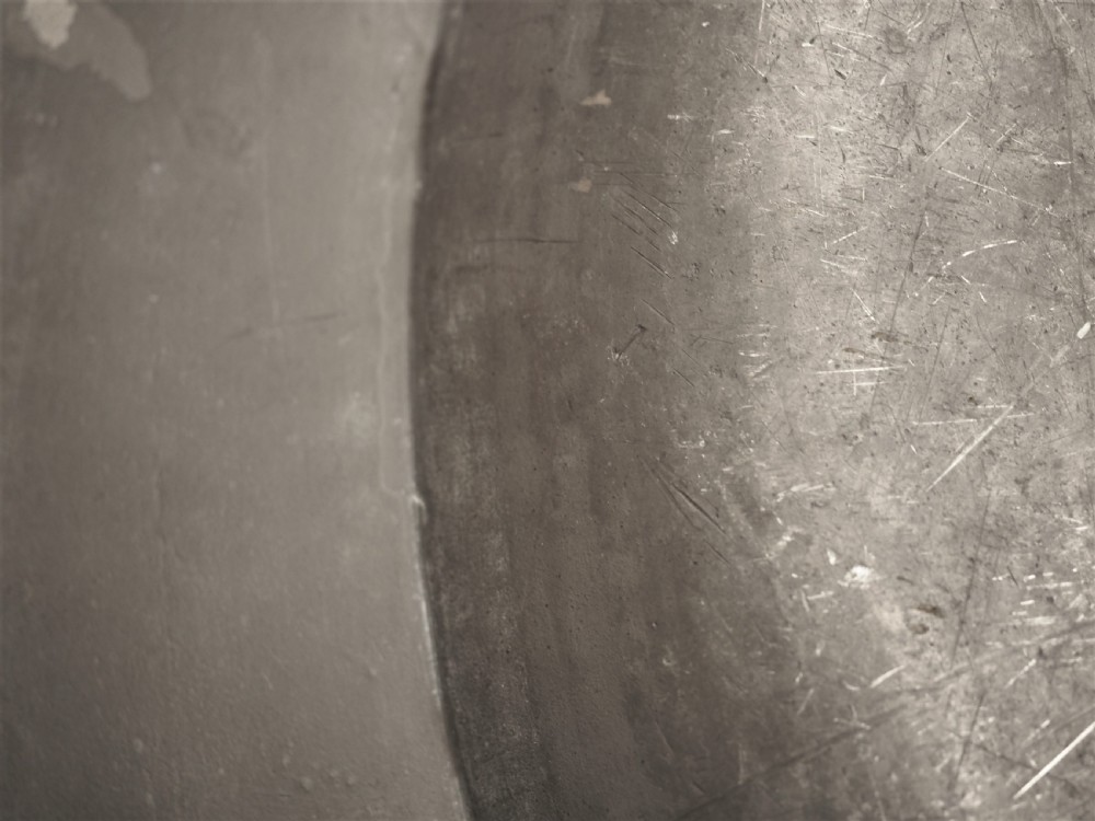 A circular 18th-century English pewter charger featuring a broad plain rim and an aged patinated surface. View VIII