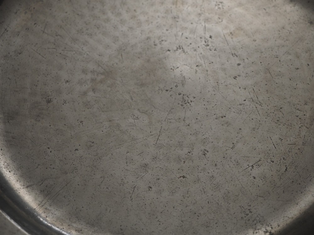 A circular late seventeenth-century grey pewter charger plate featuring a triple-reeded rim and hand-hammered surface finish. View IV