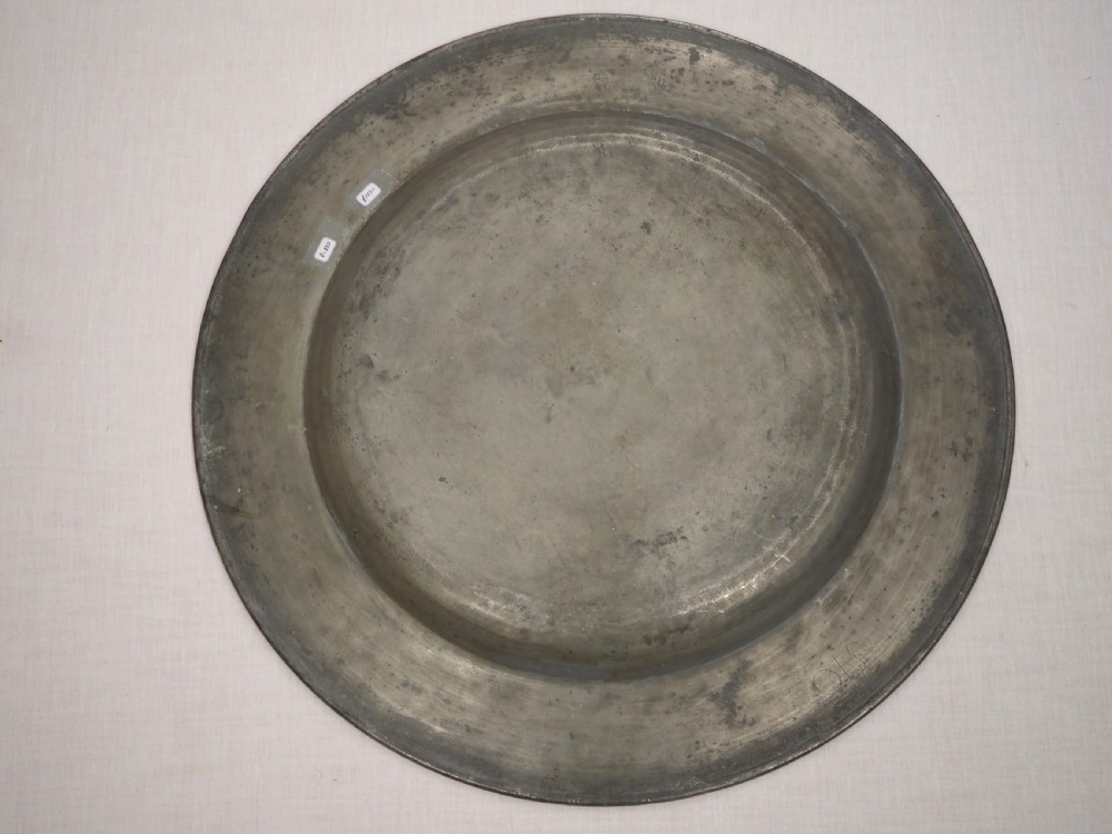 A circular late seventeenth-century grey pewter charger plate featuring a triple-reeded rim and hand-hammered surface finish. View VI