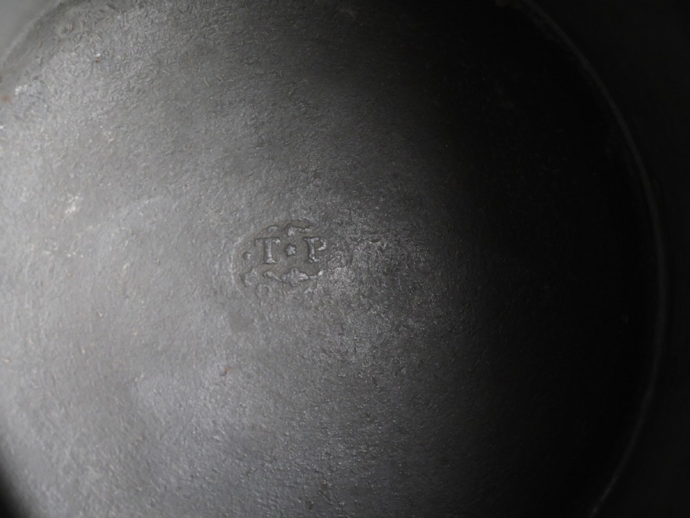 A cylindrical pewter pint measure featuring a curved handle, horizontal molded bands around the base, and stamped verification marks near the upper rim. View VII
