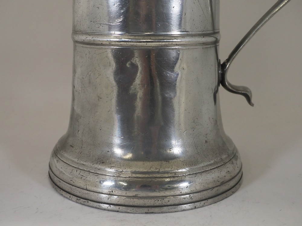 An 18th-century English pewter ale jug featuring a flared base, central girdle moulding, single poured spout, and curved handle. View III