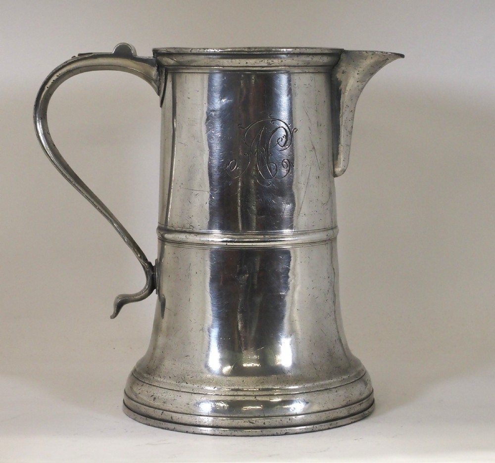 An 18th-century English pewter ale jug featuring a flared base, central girdle moulding, single poured spout, and curved handle. View IV