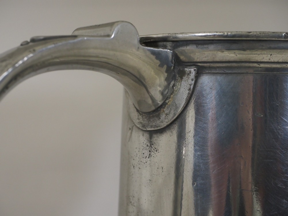 An 18th-century English pewter ale jug featuring a flared base, central girdle moulding, single poured spout, and curved handle. View VII