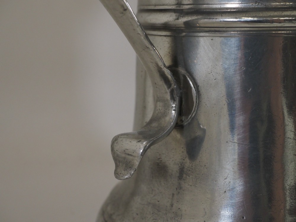 An 18th-century English pewter ale jug featuring a flared base, central girdle moulding, single poured spout, and curved handle. View VIII