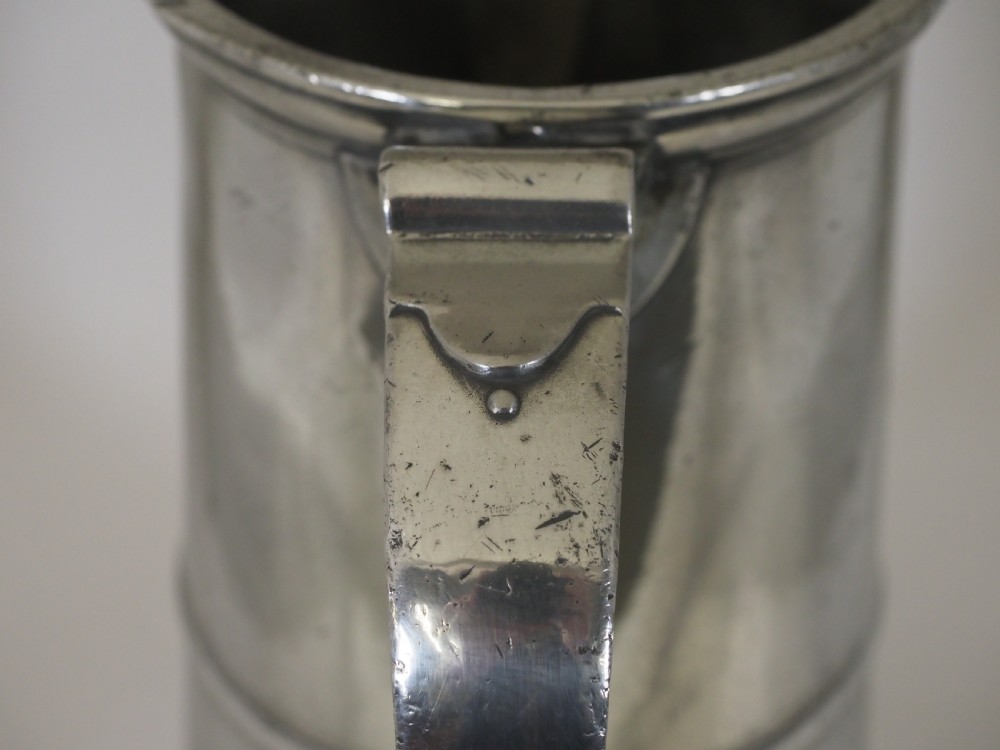 An 18th-century English pewter ale jug featuring a flared base, central girdle moulding, single poured spout, and curved handle. View XI