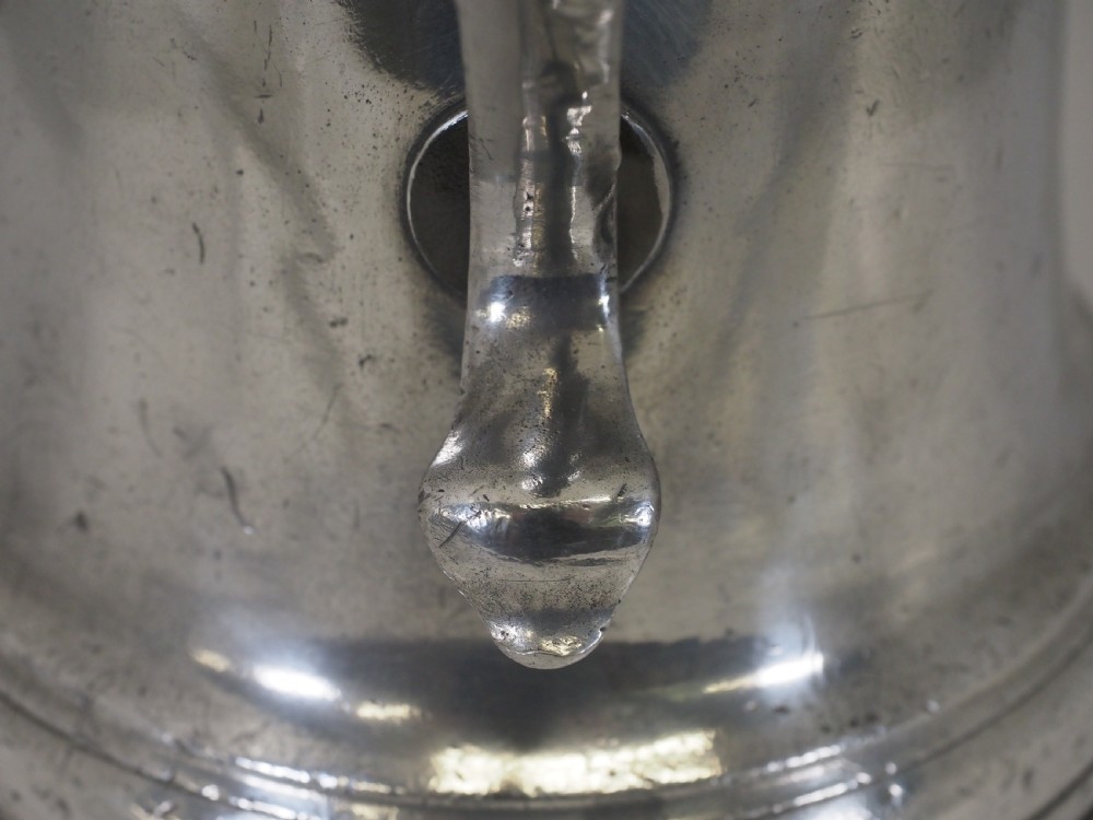An 18th-century English pewter ale jug featuring a flared base, central girdle moulding, single poured spout, and curved handle. View XII
