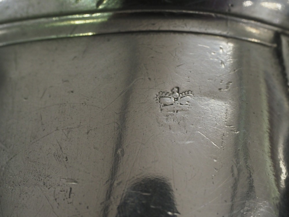 An 18th-century English pewter ale jug featuring a flared base, central girdle moulding, single poured spout, and curved handle. View XVII