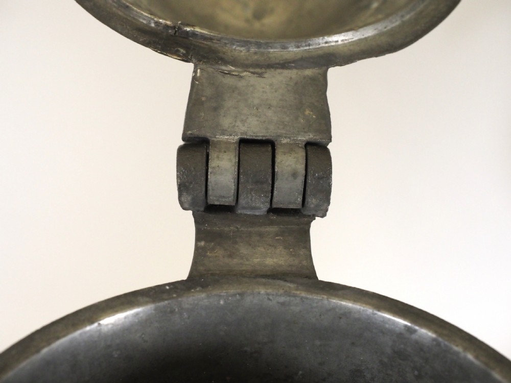 An eighteenth-century dark grey pewter spire flagon featuring a tapered cylindrical body, domed lid with spire finial, double-scroll handle, and moulded spreading base. View VII