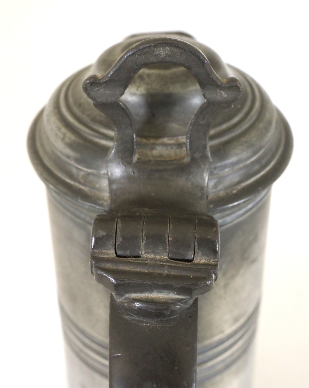 An antique late 18th-century spouted pewter spire flagon featuring a double-scroll handle, domed lid, and flared circular base. View IX