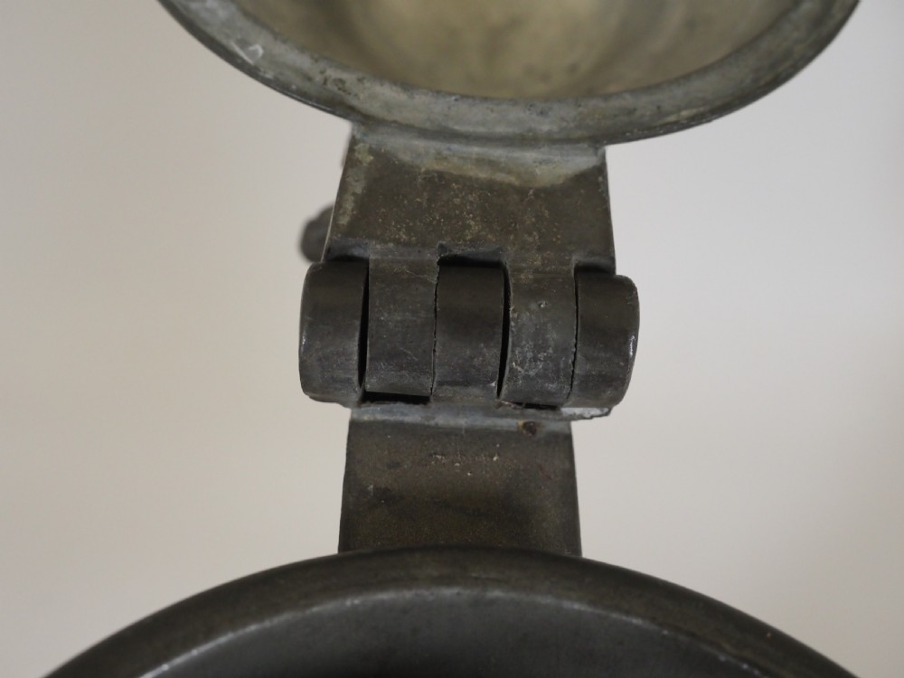 An antique late 18th-century spouted pewter spire flagon featuring a double-scroll handle, domed lid, and flared circular base. View X