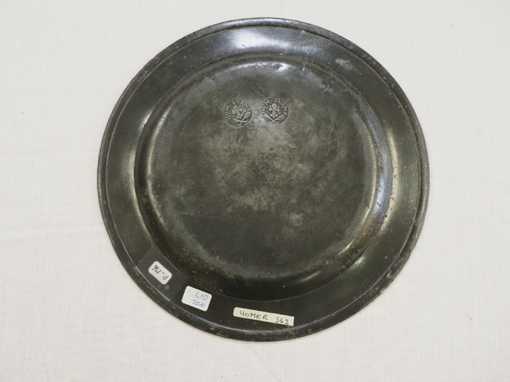 An 18th-century circular English pewter plate featuring a wide plain rim and aged grey metal patination. View IV