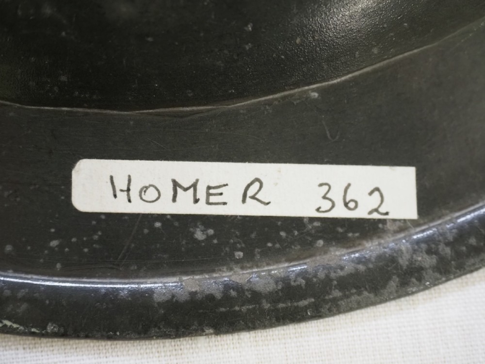 An 18th-century circular English pewter plate featuring a wide plain rim and aged grey metal patination. View VI