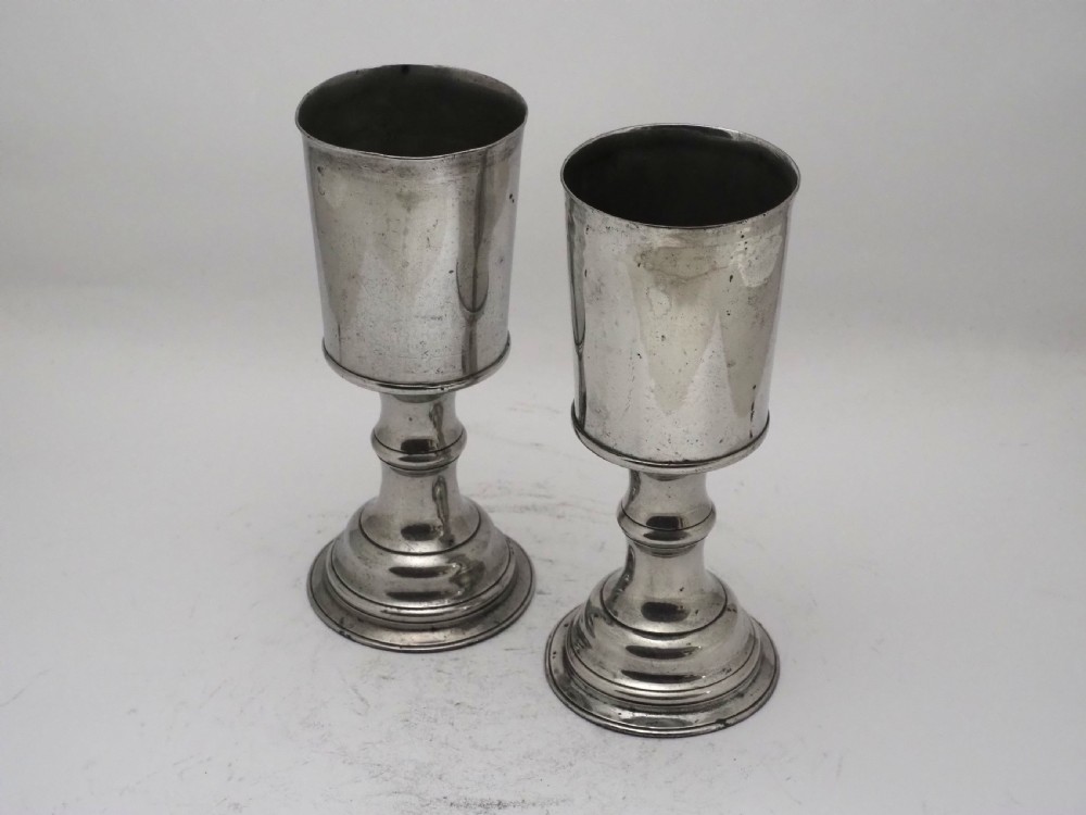 A pair of Georgian pewter chalices featuring cylindrical bowls, knopped stems, and stepped circular bases. View II