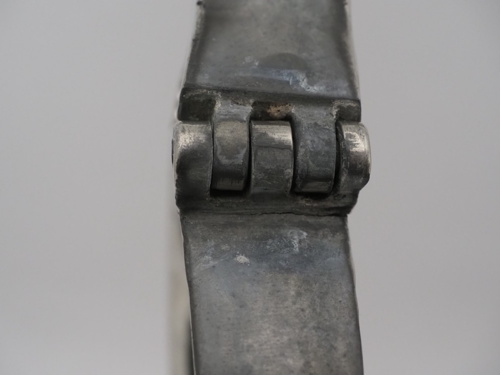 An 18th-century Irish pewter church flagon with a domed hinged lid, thumbpiece, curved handle, and broad flared base. View V