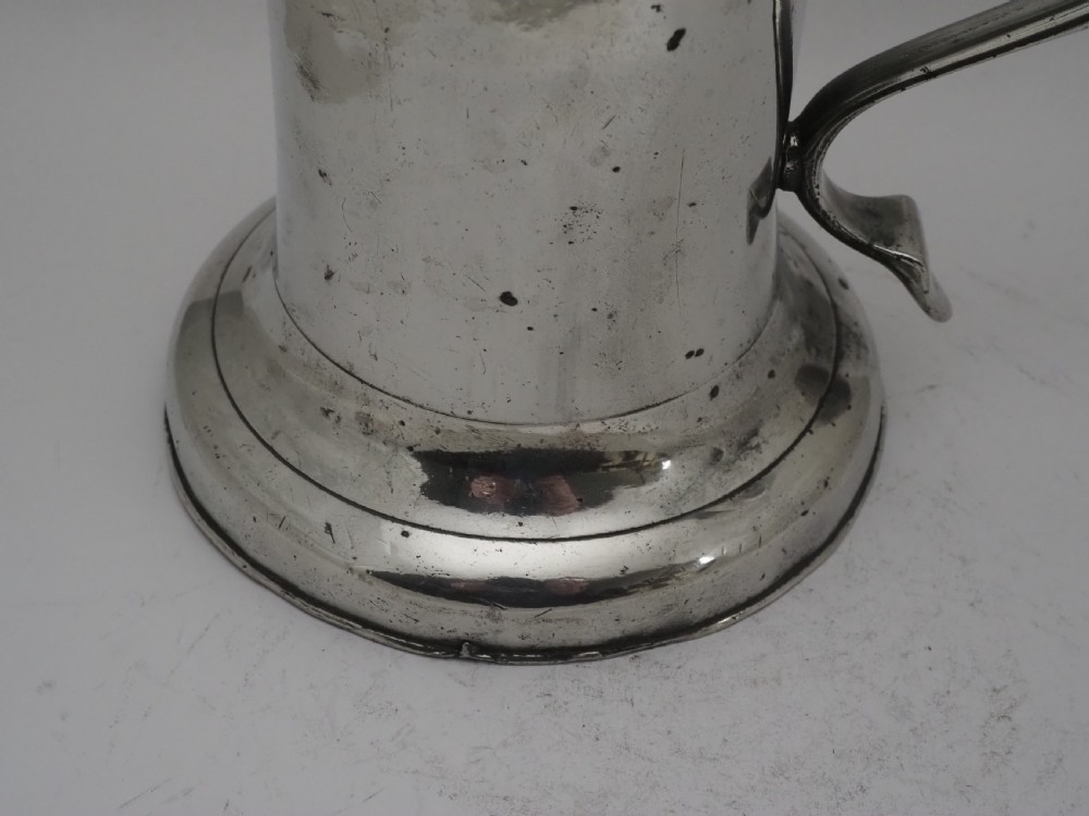 An 18th-century Georgian Irish pewter church flagon featuring a domed hinged lid, double-scroll handle, spout, and circular moulded base. View III