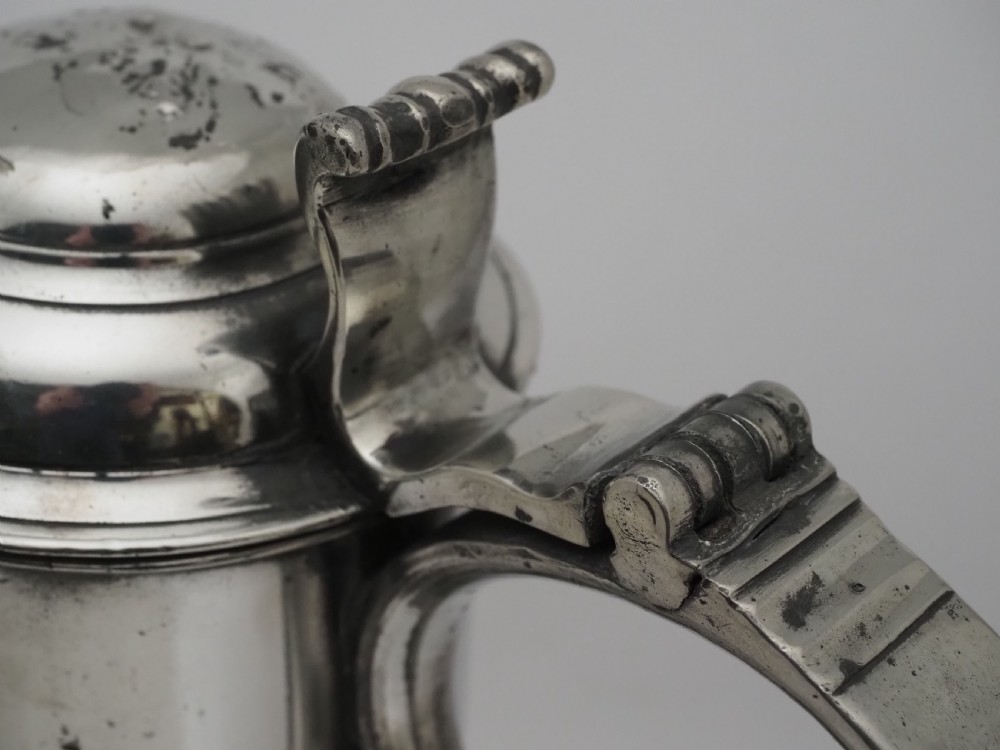 An 18th-century Georgian Irish pewter church flagon featuring a domed hinged lid, double-scroll handle, spout, and circular moulded base. View VII
